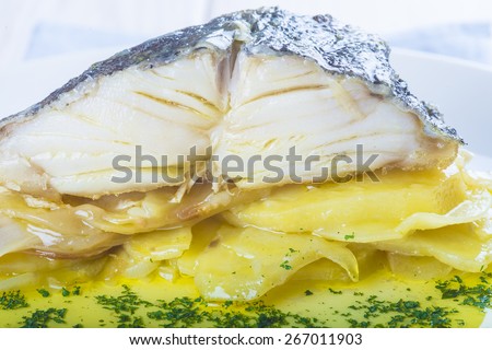 Salted cod fish oven baked with potatoes onion and olive oil