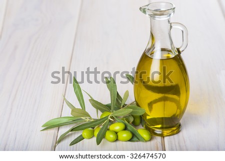 Olive oil with raw olives and its leaves
