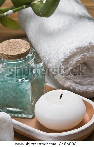 Spa background with bath salts, a towel, a candle and some things more.