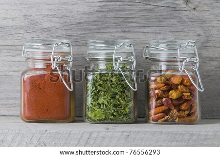 Glass jars with some spices on an old wooden stand.