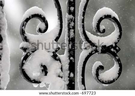 Snow on a wrought iron railing in the middle of a winter snowstorm.