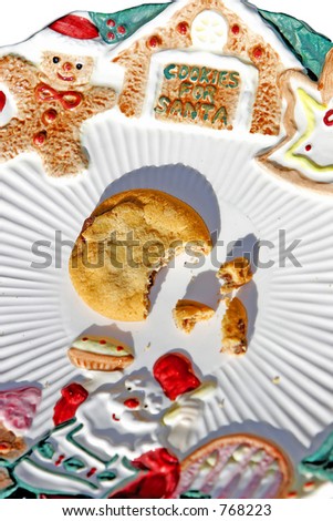 A plate for Santa\'s cookies, and he left only one half-eaten cookie left, and some crumbs (close-up).