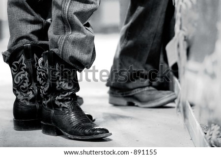 Rodeo bull rider\'s boots behind the scenes - steel black and white effect.