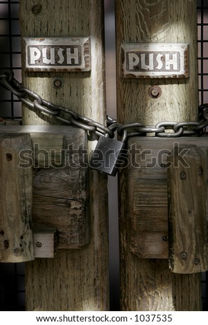 Mixed Message - Chained and padlocked doors with signs instructing to Push.