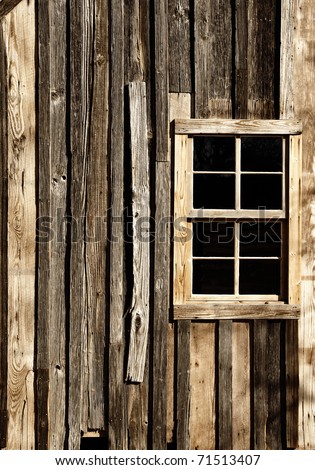 The external window and wall of a vintage wood house in the American West (sepia tint).