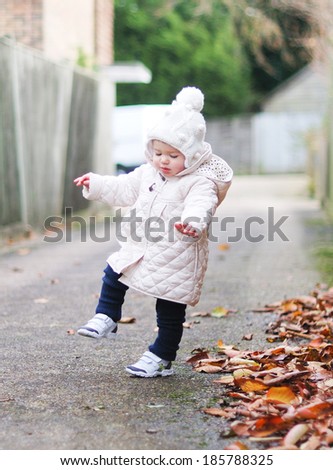 Baby in a coat lost her balance and going to fall