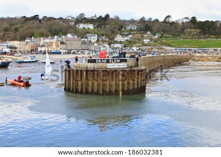 LYME REGIS, ENGLAND - APRIL 08: high tide, Lyme Regis harbour, Jurassic Coast, Dorset, England, April 08, 2012. The town is famous for the fossils found in the cliffs and beaches.