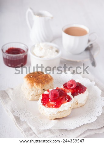 English cream teas: scones with cream and strawberry jam on the white table, selective focus