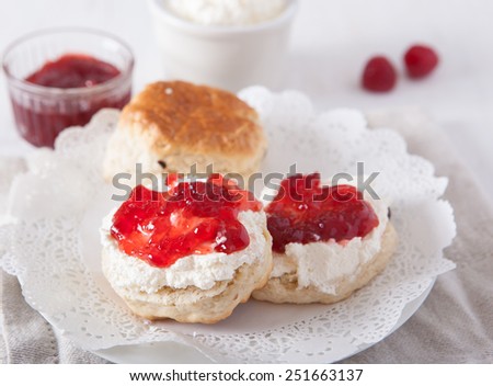 English cream teas: scones with cream and strawberry jam on the white table, selective focus