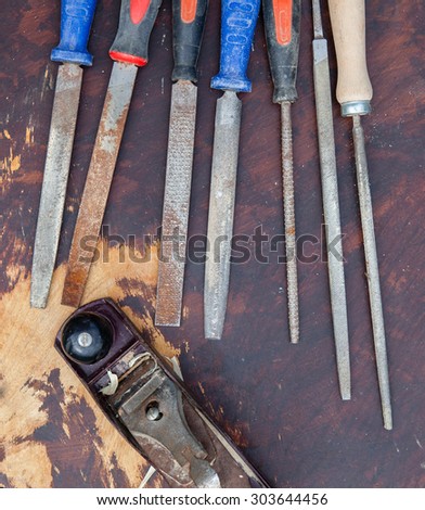 Selection of old used chisels and a plane tool on a dark wooden table, selective focus