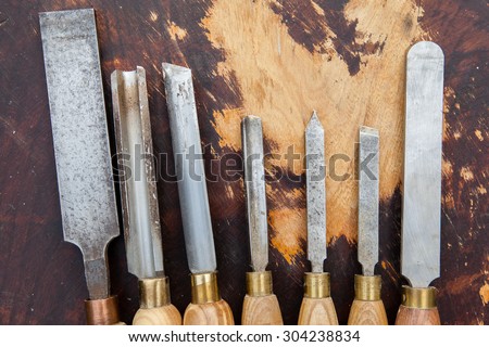 Old used wood lathe chisels selection on the dark wooden table, selective focus