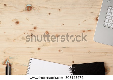 Two pads, pencils, notebook on the wooden table, empty space