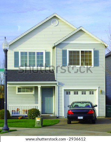 front view of a house with a car parking in front of garage.