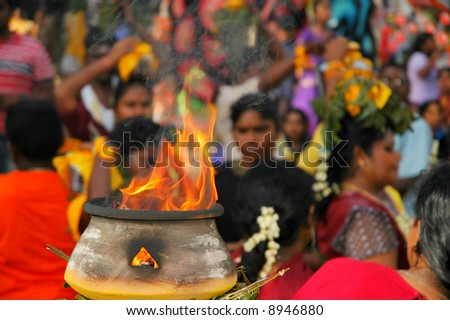 Crowd seen at an Indian (Asia) religious festival with a fire bowl as foreground and the crowd as background.