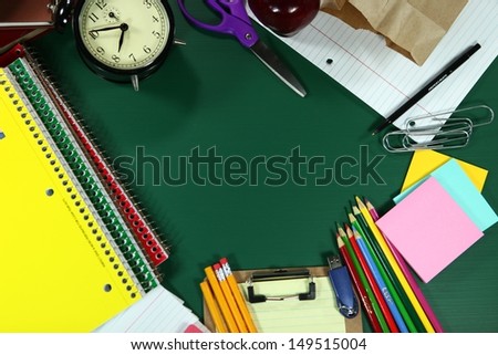 Multiple Back to School Items Arranged on a Green Blackboard