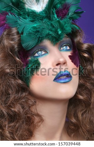 Beautiful Woman Wearing Makeup and Feathers in Beauty Conceptual Image