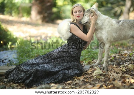Beautiful Woman Posing With a Wolf Outdoors