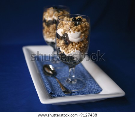 Two Blueberry Granola and Yogurt Desserts on Blue