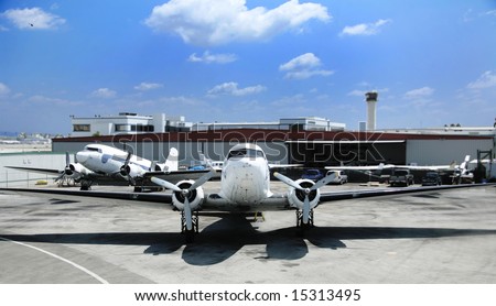 Vintage Cargo Airplane on the Runway Next to an Airport Hangar