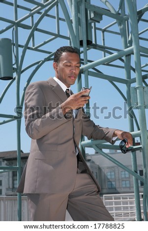 Black Business Man in a Suit Outside Reading Cell Phone