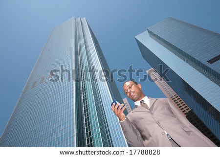 Abstract View of Black Business Man in a Suit Outdoors Looking at Cell Phone