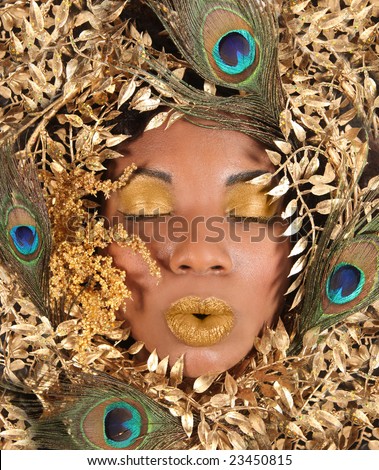 African American Woman Wrapped in Metallic Leaves and Peacock Feathers