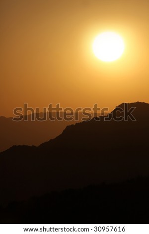Vertical Silhouette Sunrise of Hazy Misty Mountains With Warm Colors
