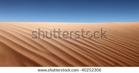 Panoramic view of desert landscape. No one is viewable in the shot. Horizontally framed shot.