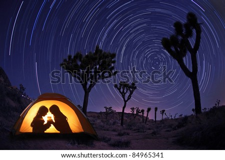 Children Camping at Night in a Tent With Star Trails