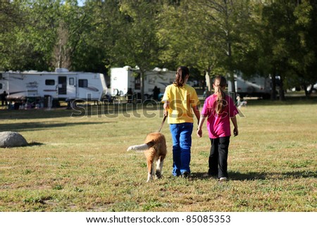 Sibling Girls Walking a Dog While Camping Outdoors