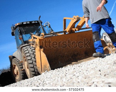 Excavator driver and his tractor on the construction site