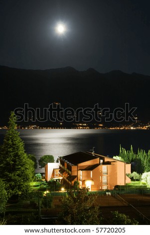 Lake Garda at night, moon shining over Monte Baldo, reflections on the lake, Limone, Italy