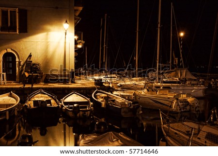 Yachts and motorboats docking at marina in at night