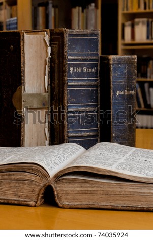 Open Bible and antique books on the table in the library