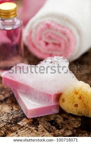 pink soap with lather  and different beauty products