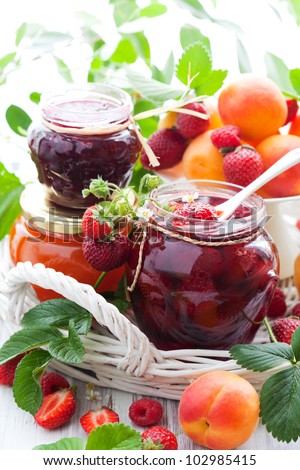 strawberry,apricot, raspberry jam in a jars and fresh berries