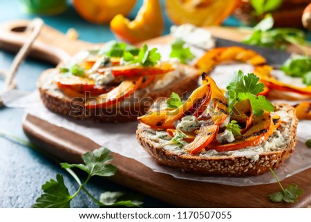 Open sandwich with grilled pumpkin and soft cheese  on multigrain rye bread.