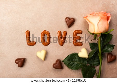 Valentine\'s day concept background with chocolate letters and rose