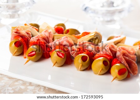 Antipasti skewers with olives, red pepper, artichoke hearts and salami.