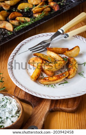 Roasted potato wedges with herbs and garlic on a plate