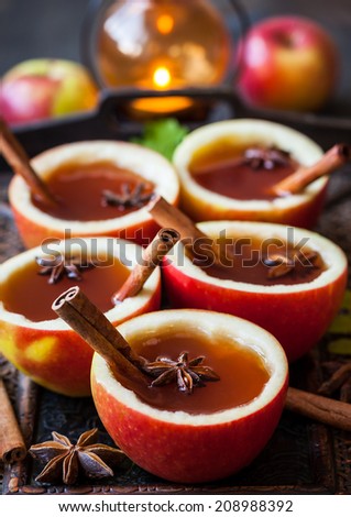 Apple cider with cinnamon sticks and anise star in apple cups