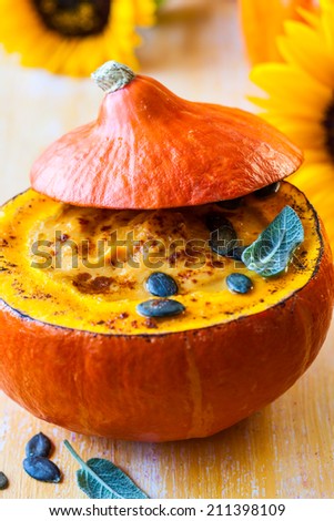 Cream of pumpkin soup with pumpkin seeds and sage  in pumpkin.Selective focus