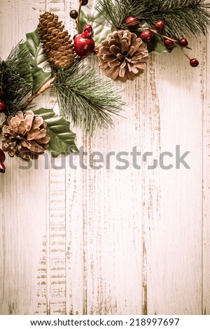 Christmas background with fir branches,pinecones and berries on the old wooden board in vintage style