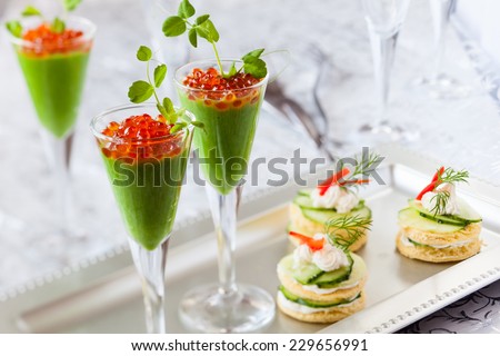 festive appetizers with avocado puree, red caviar and cucumber sandwiches