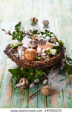 eggs in a nest with flowers,feathers on a wooden table