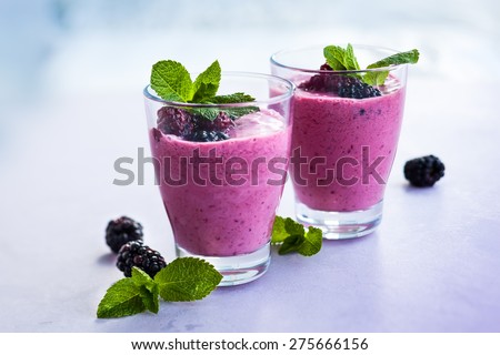 Delicious blackberry smoothie with mint and fresh berries in glasses