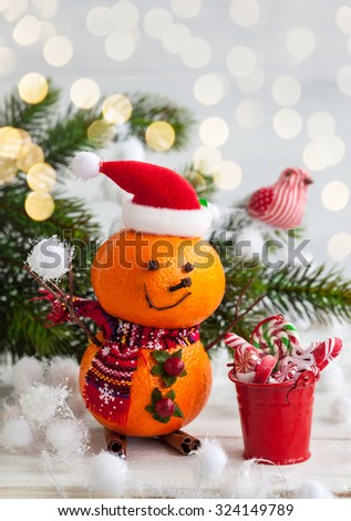 Happy snowman made out of tangerines,clove and winter berries