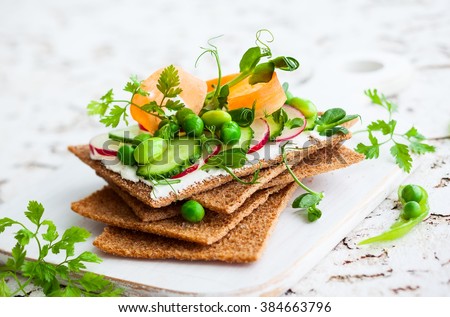 Healthy sandwiches with soft cheese and raw spring vegetables on crisp rye bread