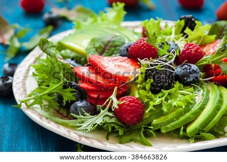 Mixed salad leaves with berries, avocado and honey-mustard dressing