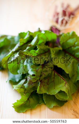 a bunch of red chard leaves on wooden  table